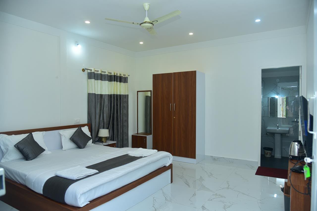 A guest room with a double bed, wardrobe and attached bathroom